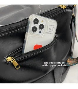 Detail of black PU leather shoulder bag featuring a front zip pocket and ethnic strap