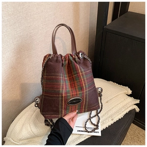 Detailaufnahme der Vintage-Karotasche mit Ledergriffen und metallischen Kettendetails