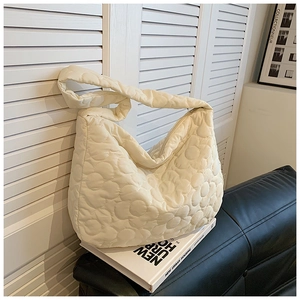 Detail of quilted flower texture on cream white nylon shoulder bucket bag