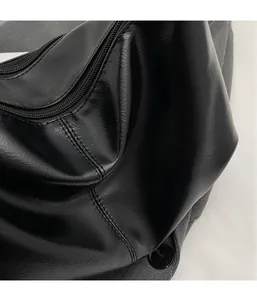 Detail of black pleated texture and high-quality stitching on a modern crossbody bag