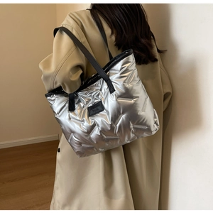 Silver quilted tote bag with puffer texture and fashion label shown on a shoulder