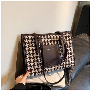 Detail of houndstooth tote bag featuring leather pocket and slim shoulder straps