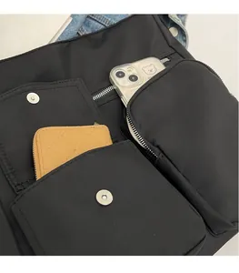 Detailed close-up of a nylon bag showing functional pockets with metal buckles and zippers