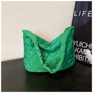 Detail view of the quilted stitching and green nylon fabric on the large tote bag