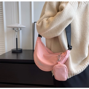 Pink nylon crescent bag detail showing the adjustable strap and mini round coin pouch