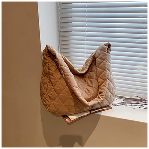 Detailed view of khaki quilted nylon tote bag with rhombic stitching on a windowsill