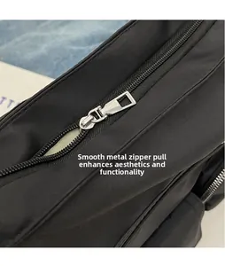 Detail of sleek silver metal zipper puller on high-density black nylon fabric bag