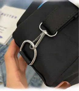Macro shot of durable silver metal swivel hook and hardware detail on black nylon bag