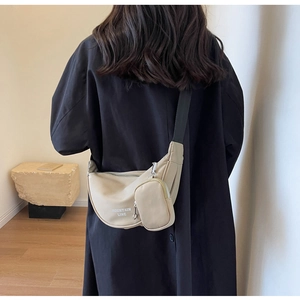 Detail of beige nylon crescent bag with Mountain Line logo and mini coin purse attachment