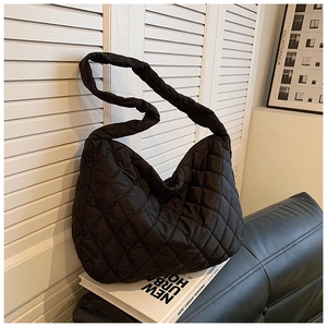 Close-up of black quilted nylon bucket bag with diamond stitching and wide strap