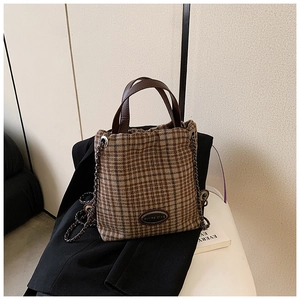 Detailansicht der Retro-Karo-Handtasche aus Tweed mit Ledergriffen und Goldkette