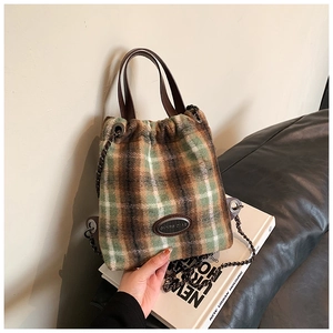 Detail der Vintage-Eimertasche aus kariertem Wollstoff mit dunkler Kette