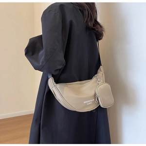 Detail of beige nylon crescent bag with adjustable strap and small detachable pouch