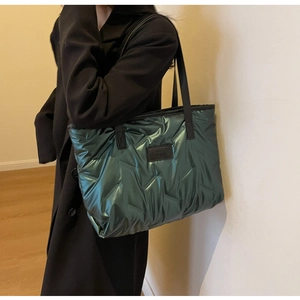 Macro shot of metallic green quilted tote bag with FASHION BAGS label and black strap