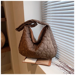 Detailed view of dark brown quilted floral texture on Oxford fabric shoulder bag