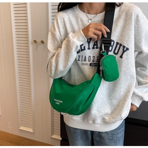 Detail of bright green nylon crescent bag with adjustable wide strap and mini pouch