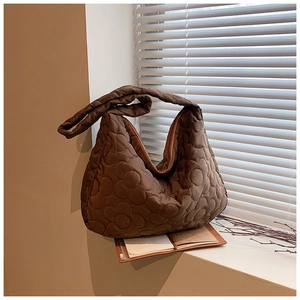 Detail of caramel quilted hobo bag with 3D floral embossing on textured oxford fabric
