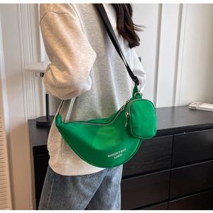 Detail view of green nylon dumpling bag with double zippers and Mountain Line text