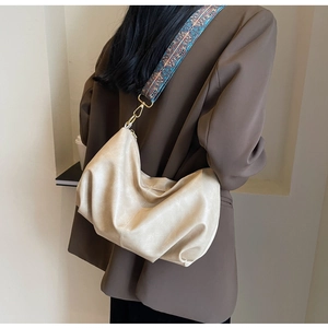 Detail of beige hobo bag featuring a patterned ethnic style wide woven shoulder strap