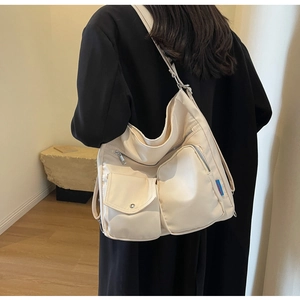 Detail der großen beigen Nylon-Einkaufstasche mit Funktionstaschen und Seitenetikett