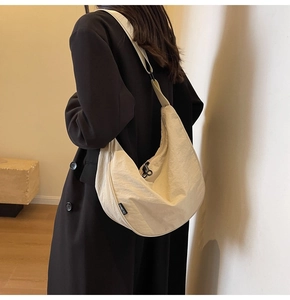 Detail of cream nylon crescent bag with textured fabric and ZOLEMAN side label