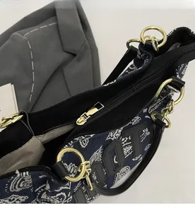 Detail of navy paisley canvas tote bag featuring black leather handle and gold-tone zipper