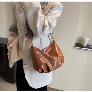 Brown pleated dumpling bag featuring a wide bohemian style patterned shoulder strap