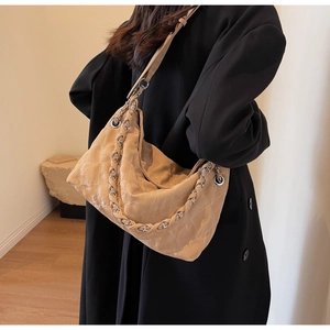 Close-up of khaki quilted shoulder bag with chain strap and diamond stitching