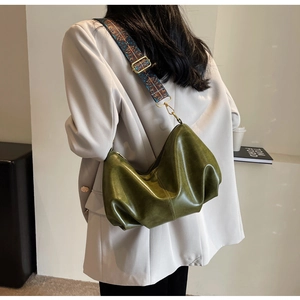 Detail of dark green dumpling bag featuring pleated leather and ethnic style wide strap