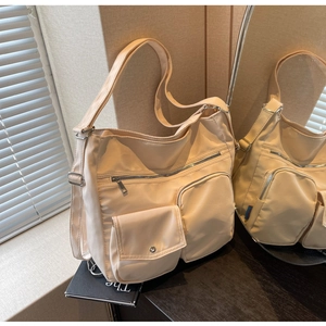 Detailaufnahme der beigen Nylon-Einkaufstasche mit funktionellen Taschen und Metallschnallen