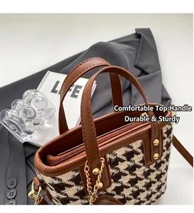 Detail of houndstooth fabric texture with brown leather trim and gold metal hardware