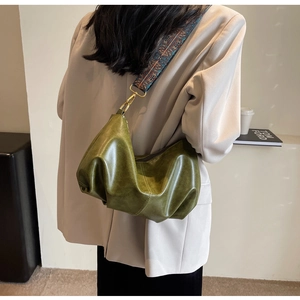 Detail of vintage green pleated dumpling bag with a bohemian ethnic pattern wide shoulder strap