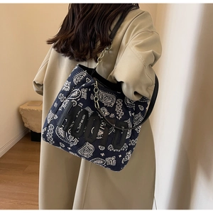 Detail of navy canvas tote bag with paisley pattern and HODTO patch shown on shoulder