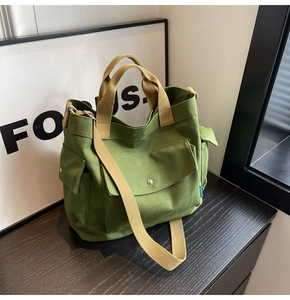 Close-up of canvas tote bag showing military green fabric and khaki multi-pocket details