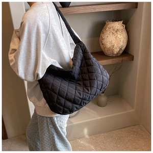 Detail shot of black quilted oxford cloth tote bag showing soft nylon texture and wide strap