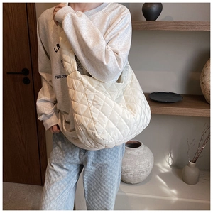 Close-up of quilted cream oxford fabric shoulder bag with padded cloud-like texture
