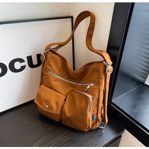 Detail der karamellfarbenen Nylontasche mit funktionellen Außentaschen und silbernen Zippern