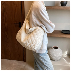 Detail of white quilted nylon hobo bag with large diamond stitching and wide strap