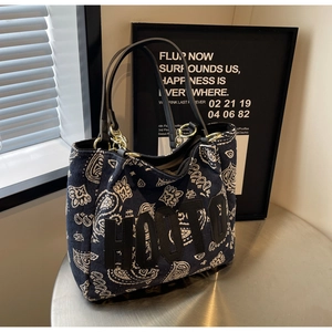 Detail of blue paisley tote bag with HOOTO letter patch and metal chain handle