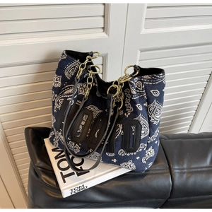 Detail of dark blue paisley canvas tote with HOPO 3D letters and gold chain strap