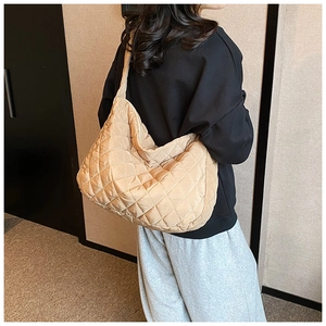Detailed view of khaki quilted hobo bag with diamond stitching and wide shoulder strap