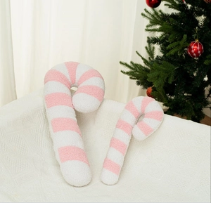 Dettaglio di cuscini di peluche a forma di bastoncino di zucchero a strisce rosa e bianche