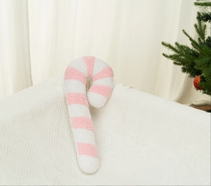 Dettaglio del cuscino di peluche a forma di bastoncino di zucchero rosa e bianco