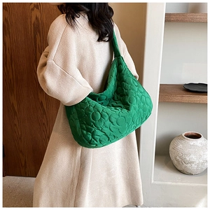 Green floral quilted oxford fabric shoulder bag worn by model in minimalist room