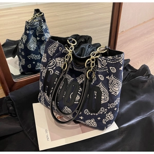 Detail of blue paisley canvas tote bag with large letter patch and chain strap
