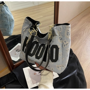Close-up of blue denim tote bag with paisley pattern and HOOIO letter embroidery