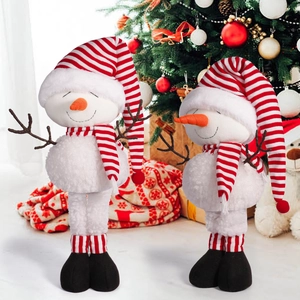 Detail of plush Christmas snowman with red striped hat and scarf on warm background