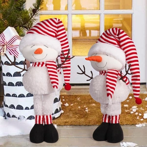 Detail of two Christmas snowman plush toys with striped hats and retractable legs