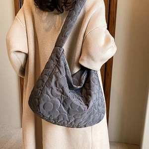 Quilted dark grey nylon shoulder bag with flower stitching pattern shown on model