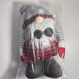 Detailed view of Christmas gnome plush with grey snowflake hat and red black plaid outfit